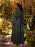 The dress is styled against a moody, dramatic backdrop, perfect for a formal event or dark romantic evening vibe.