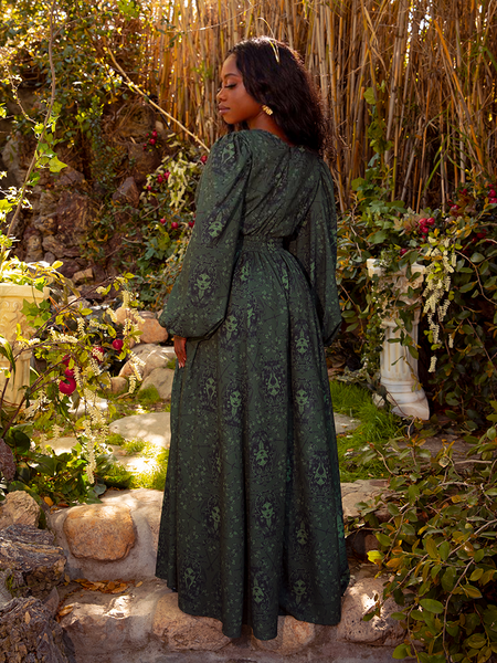 The dress is styled against a moody, dramatic backdrop, perfect for a formal event or dark romantic evening vibe.