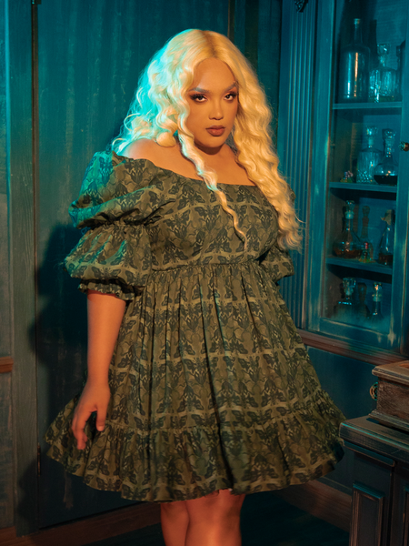 The CRIMSON PEAK™ Allerdale Moth Wallpaper Babydoll Dress in Olive is a haunting melody woven into fabric, its pattern inspired by the whispering walls of Allerdale Hall. The olive hue, deep and enigmatic, serves as the perfect canvas for the intricate moth design, symbolizing transformation and the fleeting nature of beauty. This dress, with its ethereal babydoll silhouette, invites you to embrace the mystery and allure of gothic elegance.