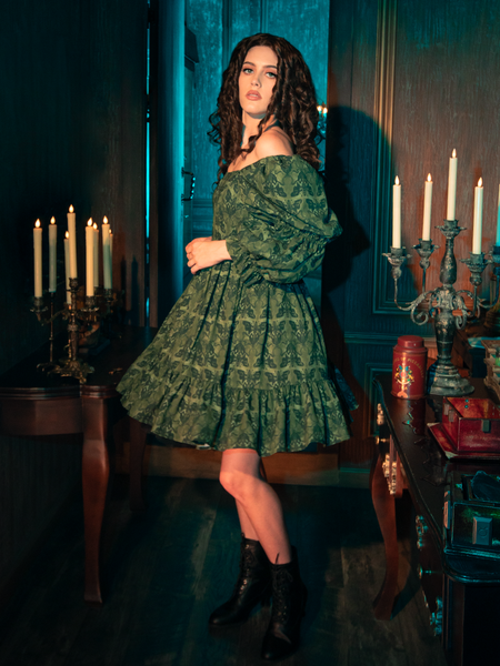 Enveloped in the olive enchantment of the Allerdale Moth Wallpaper Babydoll Dress, you are a vision of gothic grace. The dress, with its playful yet poignant moth design, flutters with the mysteries of CRIMSON PEAK™, inviting onlookers to delve deeper into the story woven within its fabric.