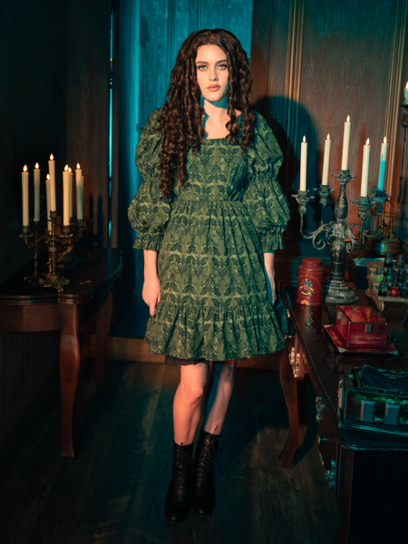 The CRIMSON PEAK™ Allerdale Moth Wallpaper Babydoll Dress blends the natural and the supernatural, its olive fabric adorned with moth motifs that speak to the gothic soul of nature. This dress, with its simple yet captivating design, is a reminder of the beauty that thrives in the shadows, waiting to be discovered.