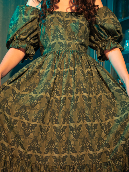Wrapped in the Allerdale Moth Wallpaper Babydoll Dress, you are an embodiment of the eternal night. The olive fabric, as deep and mysterious as the forest at midnight, is adorned with moths that navigate by the moon's glow. This dress is a celebration of the unseen, the untold, and the unforgettable.