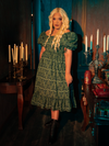 Enveloped in the olive enchantment of the Allerdale Moth Wallpaper Babydoll Dress, you are a vision of gothic grace. The dress, with its playful yet poignant moth design, flutters with the mysteries of CRIMSON PEAK™, inviting onlookers to delve deeper into the story woven within its fabric.