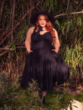 The Ambrosia Dress in Black is a darkly romantic creation. With its timeless design and luxurious fabric, it evokes the spirit of gothic poetry and forbidden love, perfect for candlelit soirées.