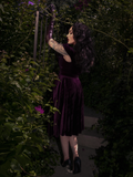 Styled with pin-up hair and winged eyeliner, the look is completed with vintage heels and a bold lip.