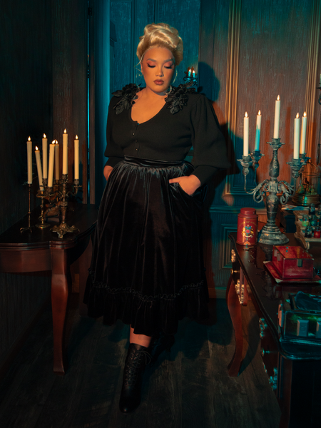 The Victorian Velvet Bustle Skirt in Black, with its haunting allure, is elegantly displayed by models from the gothic clothing brand La Femme en Noir.