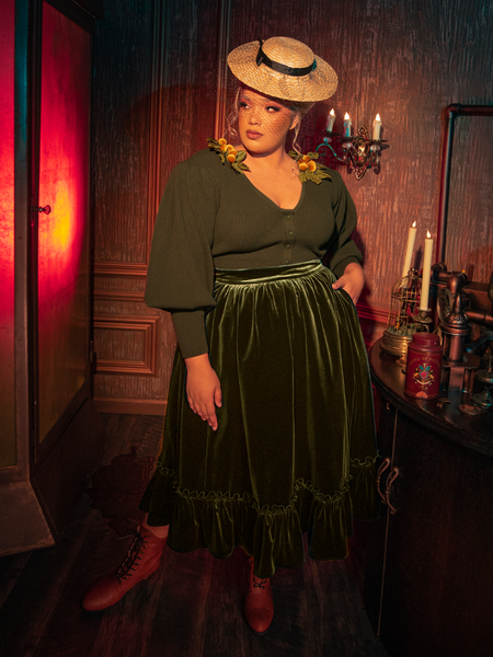 Captivating models embody the haunting allure of the Victorian Velvet Bustle Skirt in Olive, a standout creation from the gothic clothing brand La Femme en Noir.