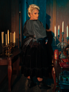 Witness the mysterious charm of the Victorian Velvet Bustle Skirt in Black as models from La Femme en Noir flaunt its hauntingly beautiful design.