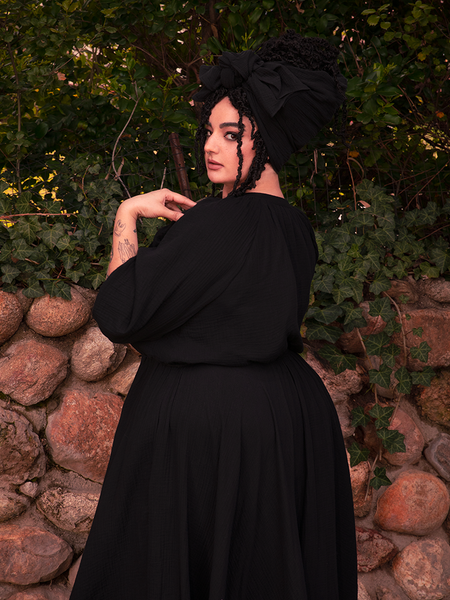 The gothic dress absorbs candlelight, glowing like old velvet in a haunted manor.