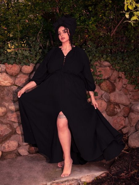 The gothic dress becomes a living silhouette, wrapped in darkness and cathedral light.