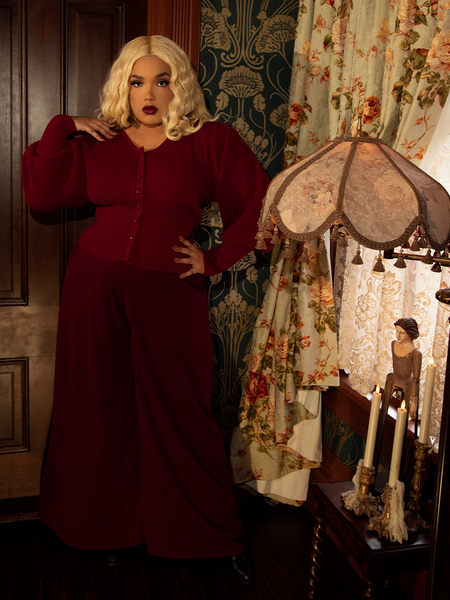 Tailored at the waist and liberated below, they drape like a dark enchantress’s spell—bewitching in oxblood's haunting glow.