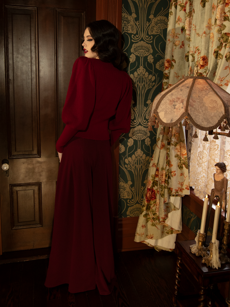 Accented with pleats that echo cathedral columns, the pants merge sacred structure with forbidden fluidity.