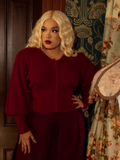 Inspired by Victorian cycling ensembles, this fitted crimson cardigan boasts a regal high neckline, voluminous sleeves, and exquisite button detailing.