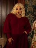 As rich as velvet roses, this crimson Victorian knit cardigan exudes old-world charm with intricate knit details, a tailored waist, and statement buttons.
