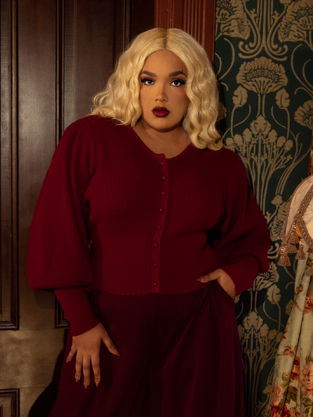 As rich as velvet roses, this crimson Victorian knit cardigan exudes old-world charm with intricate knit details, a tailored waist, and statement buttons.