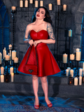 Clad in the BRAM STOKER'S DRACULA Quilted Order of the Dragon Armor Skater Skirt in Blood Red Vegan Leather, Micheline Pitt unveils her gothic elegance within a candle-lit dungeon, thanks to the fashion-forward label, La Femme en Noir.