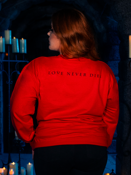 Radiating beauty, a captivating human model showcases the "Love Never Dies" Sweatshirt in Red, an exquisite piece from La Femme en Noir's BRAM STOKER'S DRACULA collection.