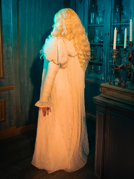 The CRIMSON PEAK™ Edith Victorian Gown whispers tales of ivory elegance, its fabric and lace telling stories of candlelit dances and stolen kisses. This gown is a tribute to the silent language of fashion, where every fold and every stitch speaks volumes of the wearer's depth and complexity.