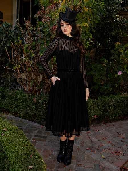 Antique-inspired buttons trace the bodice, each one a tiny relic from a gothic dreamscape.