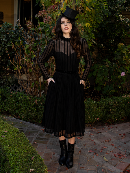 Cinched at the waist, the dress embraces curves with subtle strength—an ode to feminine power in moments of loss.