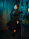 The Haunted Beauty dress is a symphony of whispering black lace, its Victorian elegance accentuated by the hauntingly beautiful capelet. This ensemble speaks of a time when mourning was an art, and love was immortalized in the very fabric of fashion.