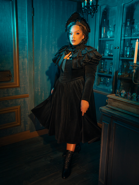 The Haunted Beauty dress is a symphony of whispering black lace, its Victorian elegance accentuated by the hauntingly beautiful capelet. This ensemble speaks of a time when mourning was an art, and love was immortalized in the very fabric of fashion.