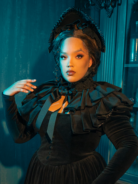 This Victorian Mourning Dress is an enchantment woven in black, its fabric the canvas for a love story written in shadows. The capelet, soft and ethereal, is a final whisper of goodbye, a delicate shroud for the beauty that lies in mourning.
