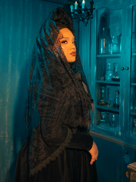 Eclipse of the Heart Lace Mourning Scarf Veil in Black: Step into the shadow of romance with the Eclipse of the Heart Lace Mourning Scarf Veil. This bewitching accessory is woven from premium black lace, designed to drape gracefully over the contours of your face and shoulders, creating an aura of mystique and allure.