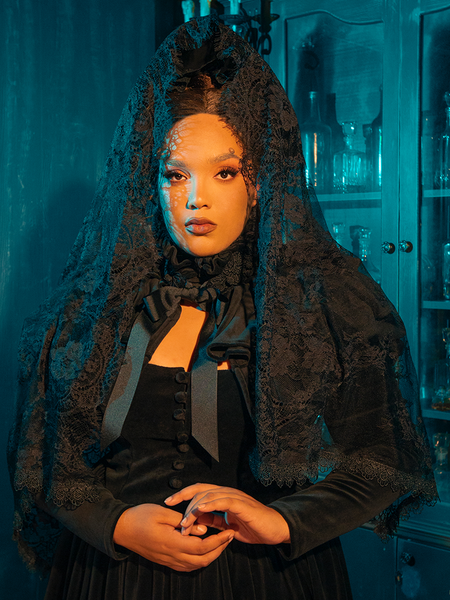 Whispers of Midnight Lace Mourning Scarf Veil in Black: Enshroud yourself in the Whispers of Midnight Lace Mourning Scarf Veil, a delicate confection of fine black lace that dances with the secrets of the night. This ethereal veil is crafted from the softest lace, featuring intricate floral patterns that cascade over the shoulders, adding a touch of somber beauty to any ensemble. Ideal