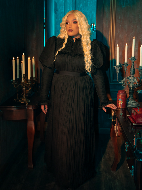 The Lady Mourning Victorian Gown in Black is a masterpiece of gothic elegance, enveloping the wearer in layers of sumptuous velvet and delicate lace. Its high collar and long, flowing sleeves whisper tales of yesteryear, while the fitted bodice and sweeping skirt promise a silhouette that's as haunting as it is graceful. 