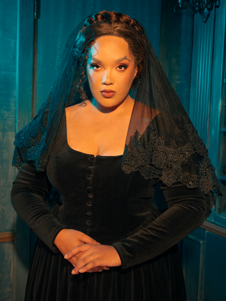 Casting an air of pensive contemplation and dark sophistication, a Gothic female model artfully exhibits the Ornate Victorian Lady Mourning Veil from La Femme en Noir, portraying a captivating fusion of mystery and depth in each carefully curated pose.