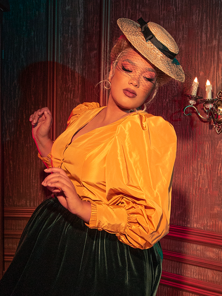 The Taffeta Edwardian Blouse in Marigold, with its haunting beauty, is displayed by captivating models from the gothic clothing brand La Femme en Noir.