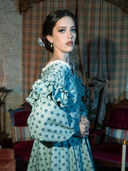 Step into a realm of gothic grace with this Victorian-inspired dress, its rich blue floral fabric and sweeping skirt evoking ethereal charm.