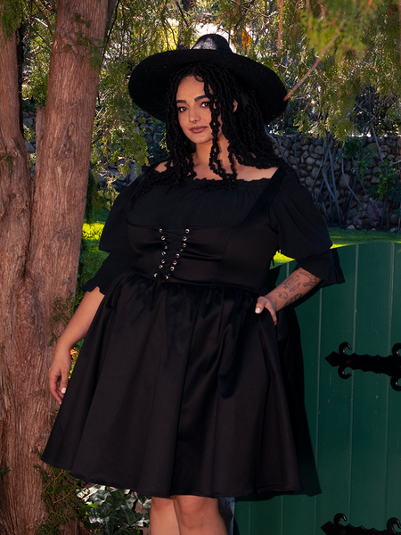 Bell sleeves cascade like twilight veils, casting silhouettes as mysterious as the night.