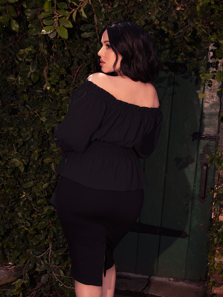 A wide neckline dips into a dark reverie, perfect for silver chokers and dusky dreams.