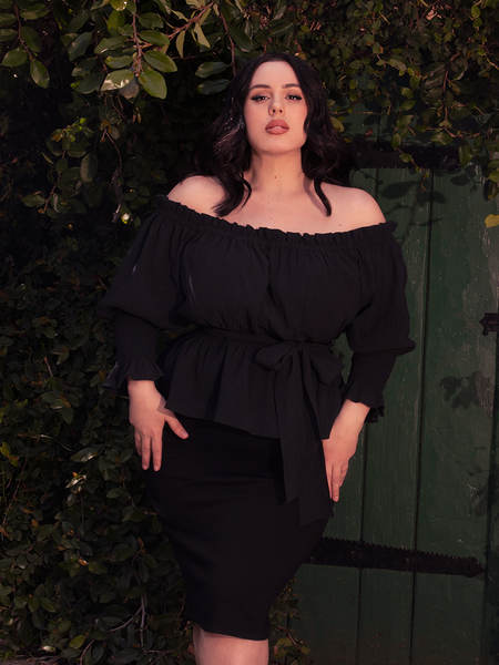 Shrouded in darkness, the Ritual Peasant Top in Black drapes the form in soft viscose, with lace-trimmed sleeves whispering secrets of the past.