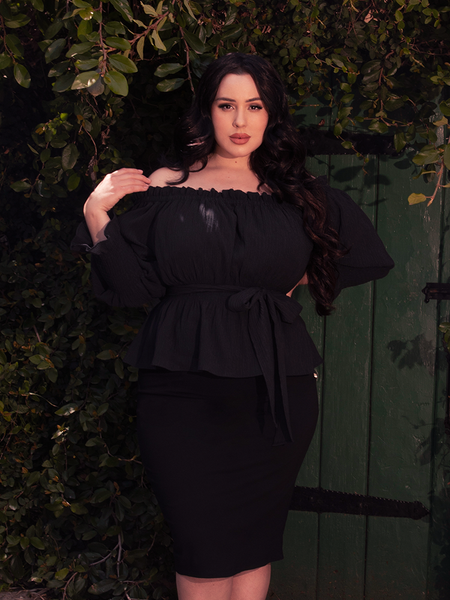 Gentle gathers at the waist bloom like a midnight rose, shadowed in the allure of gothic charm.