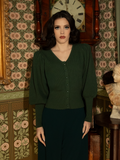 A must-have for romantic souls, this Victorian knit cardigan embraces antique charm with puffed sleeves, a buttoned front, and the rich, mystical hue of deep hunter green.
