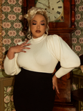 A nod to Victorian cycling fashion, this ivory pullover exudes sophistication with its structured bodice, puffed shoulders, and ornate button detailing.