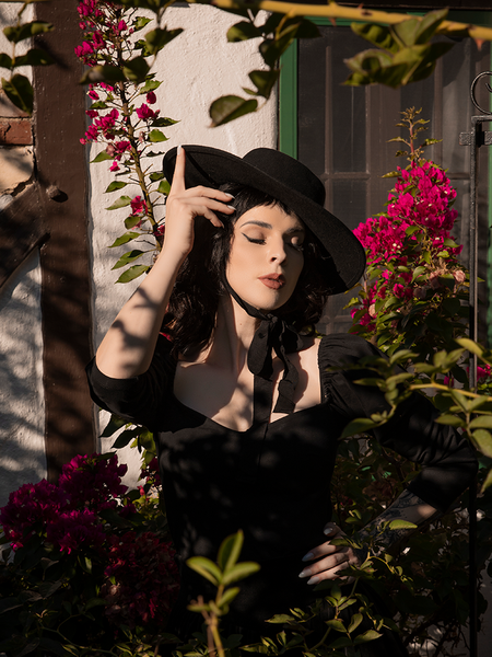 The Bolero Hat in Black worn by a model with raven black hair to complete her all black gothic dress enemble.
