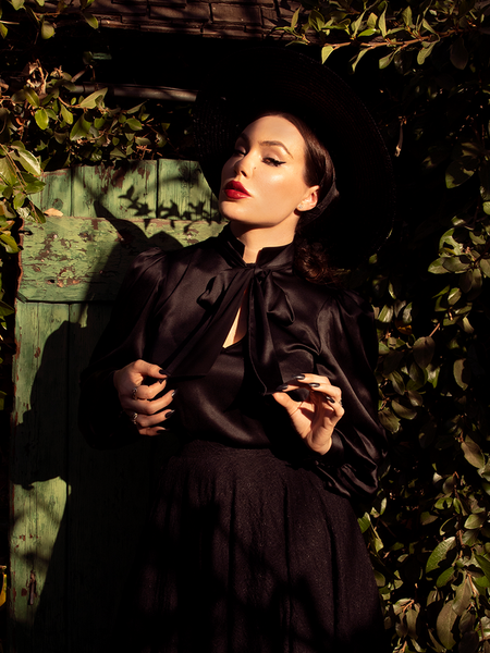 Micheline Pitt pulling out the collar ties on her Victorian Blouse in Black.