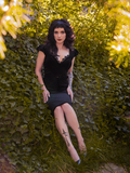 Stephanie stares directly into the camera while wearing an all new goth style dress from La Femme en Noir - the Baudelaire Wiggle Dress in Black.