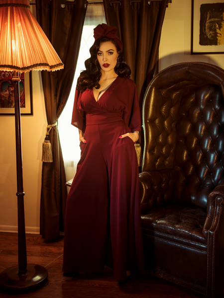 With her hands in her pockets, Micheline Pitt models the Black Widow palazzo pants in oxblood by La Femme En Noir.