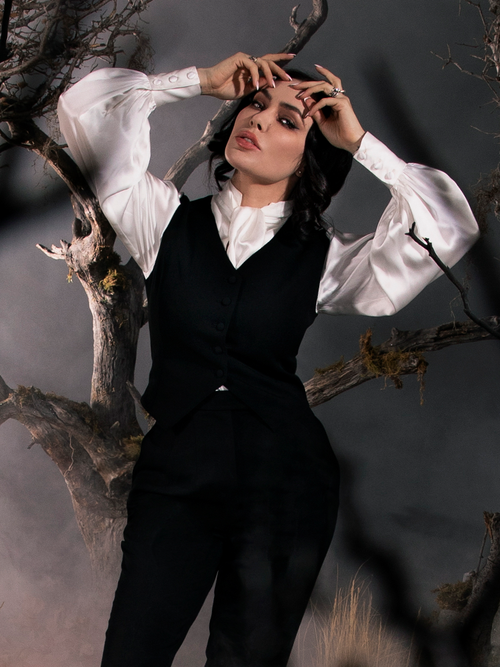 Micheline Pitt standing in a foggy forest setting wearing the Sleepy Hollow Ichabod Vest in Black.