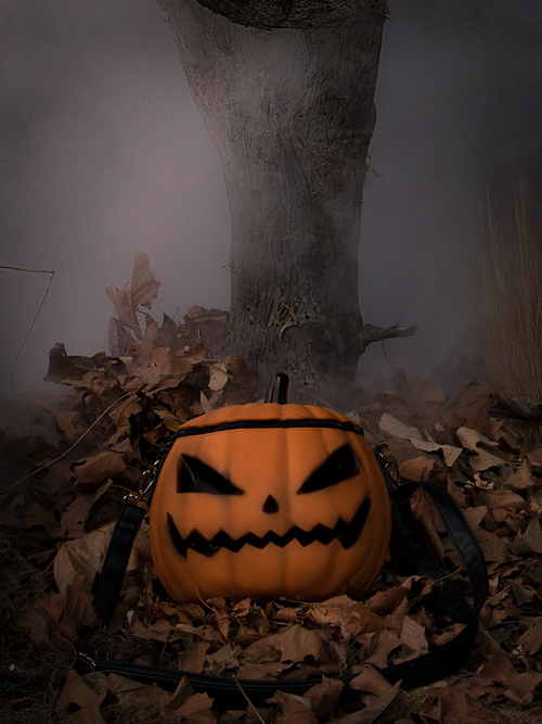 The Sleepy Hollow Pumpkin Bag photographed in front of a fog covered tree sitting on a bed of old leaves. 