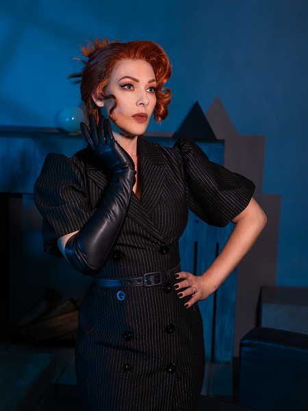 Red haired model looking wistfully off camera while modeling the BEETLEJUICE™ Delia Dress.