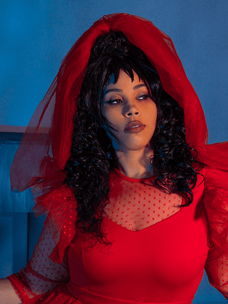 Model looking off-camera while wearing the Tulle Veil in Red.