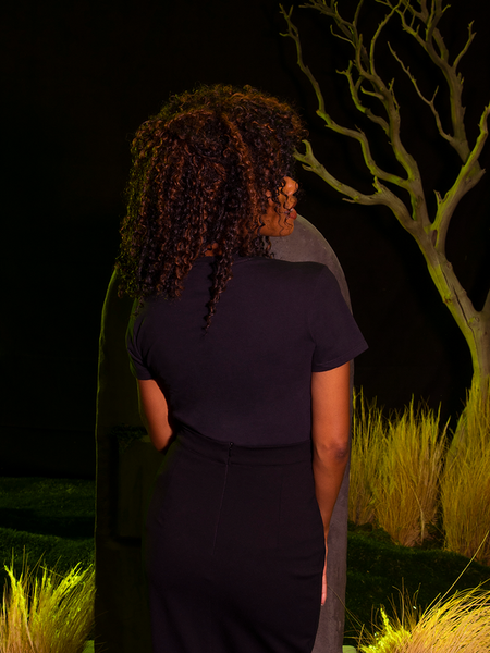 The back of the BEETLEJUICE™ Lydia Dead Tee tucked into black cigarette pants. All items available from La Femme en Noir.