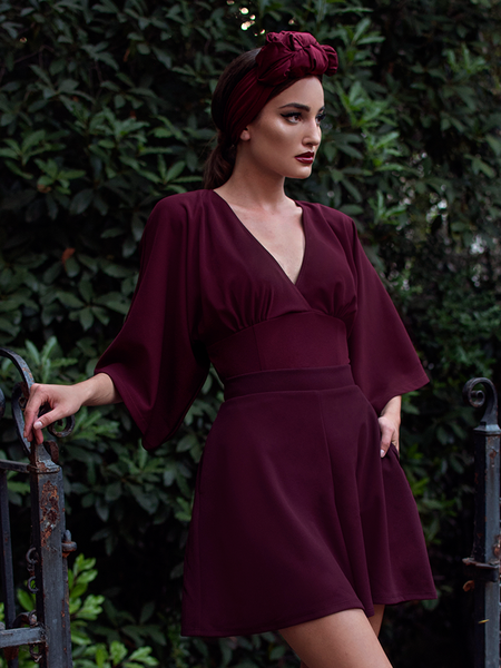 Aliza, looking away from the camera, models the Black Widow tap shorts in oxblood by La Femme En Noir.