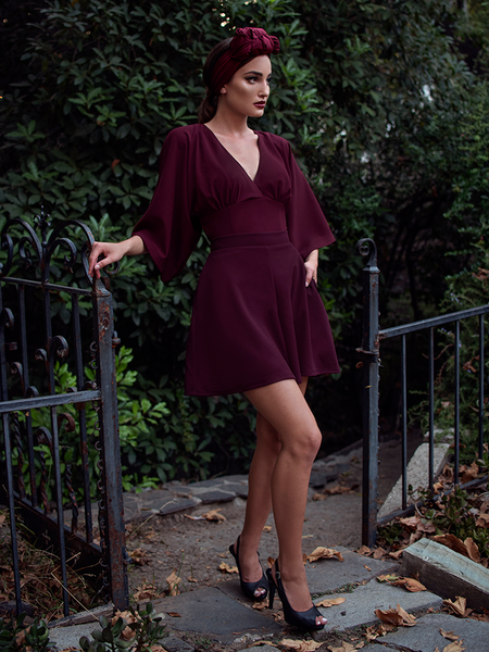 Aliza, with her hand in her pocket, models the Black Widow tap shorts in oxblood by La Femme En Noir.